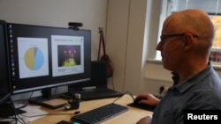 University of Copenhagen post-doctoral researcher Jeppe Have Rasmussen shows how spectrograms of pig calls are analysed on a computer in Copenhagen, Denmark, October 22.