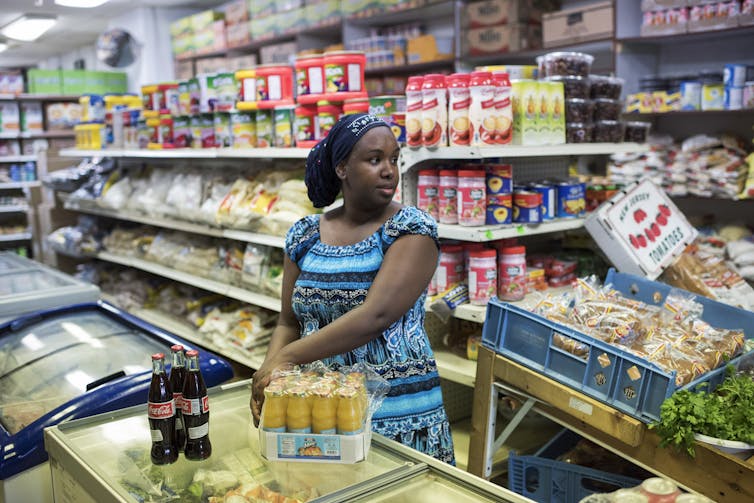 A business owner stocks her grocery store.