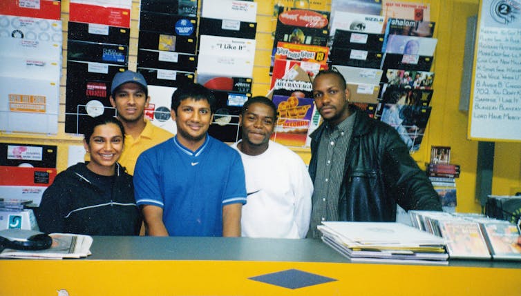 People smiling for the camera in a record store