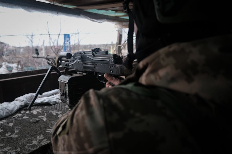 A Ukrainian gunners fires his weapon from the windown of a destroyed house on the front lines in Vuhledar, eastern Ukraine, March 2023.