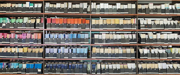 stacks of coloured old journals on library shelves.