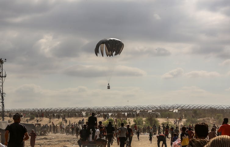 Humanitarian aid being dropped in a displacement camp in Gaza.