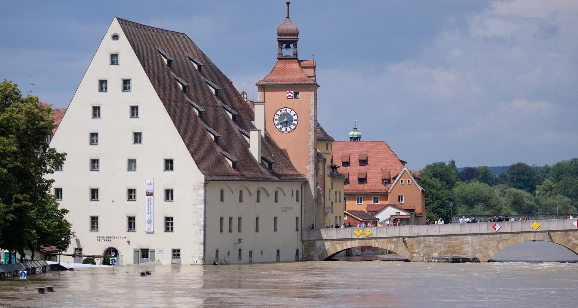 Bayern, Regensburg: Menschen stehen in der Altstadt auf der Steinernen Brücke und schauen sich das Hochwasser an. (Archivbild)