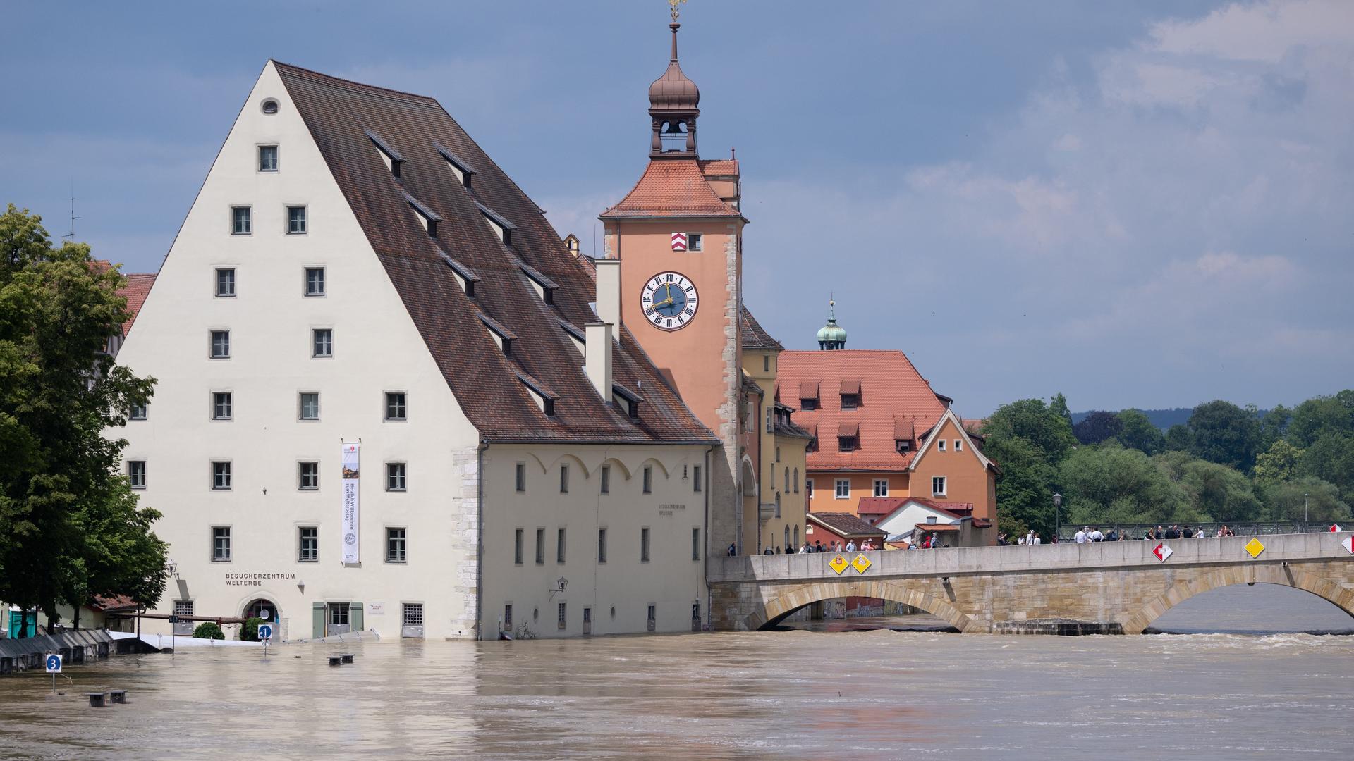 Bayern, Regensburg: Menschen stehen in der Altstadt auf der Steinernen Brücke und schauen sich das Hochwasser an. (Archivbild)