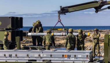 Soldiers load an AIM-120C-7 into a Nasams air-defense system