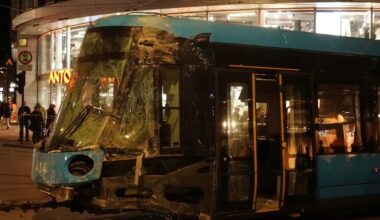 People stand near a tram after it was pulled out of a shop it crashed into, in Oslo, Norway.