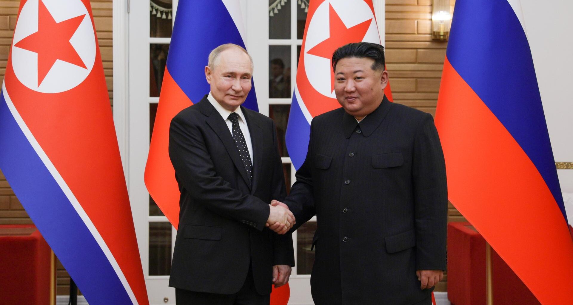 Der russische Präsident Wladimir Putin mit dem nordkoreanischen Staatschef Kim Jong-un vor Fahnen.