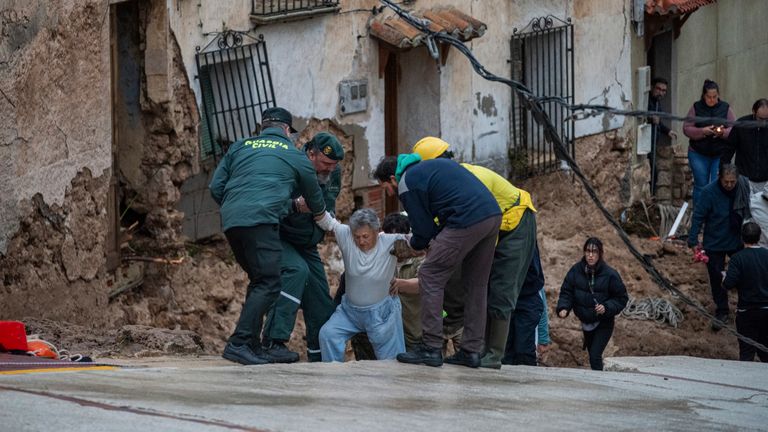 Emergency workers help an elderly lady in Letur. 
Pic: Europa Press via AP