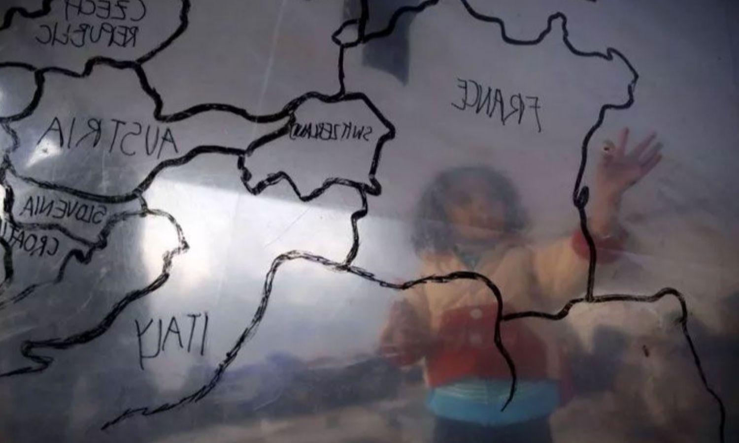 A refugee child looks at a map of Europe inside a makeshift tent at a refugee camp near the registration center on the Greek island of Lesbos - March 23, 2016 (Reuters)