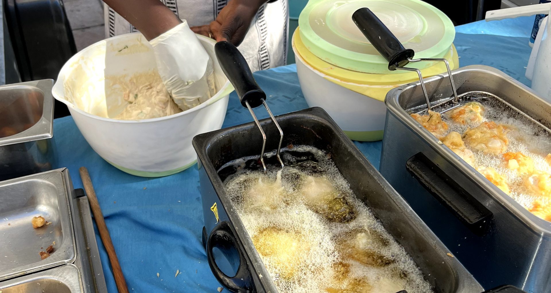 A Senegalese farmers’ market purveyor molds balls of batter and dips them into a bubbling tub of oil to form delicious pumpkin caribbean fritters. These accras reflect the high quality of food found throughout the local French market.