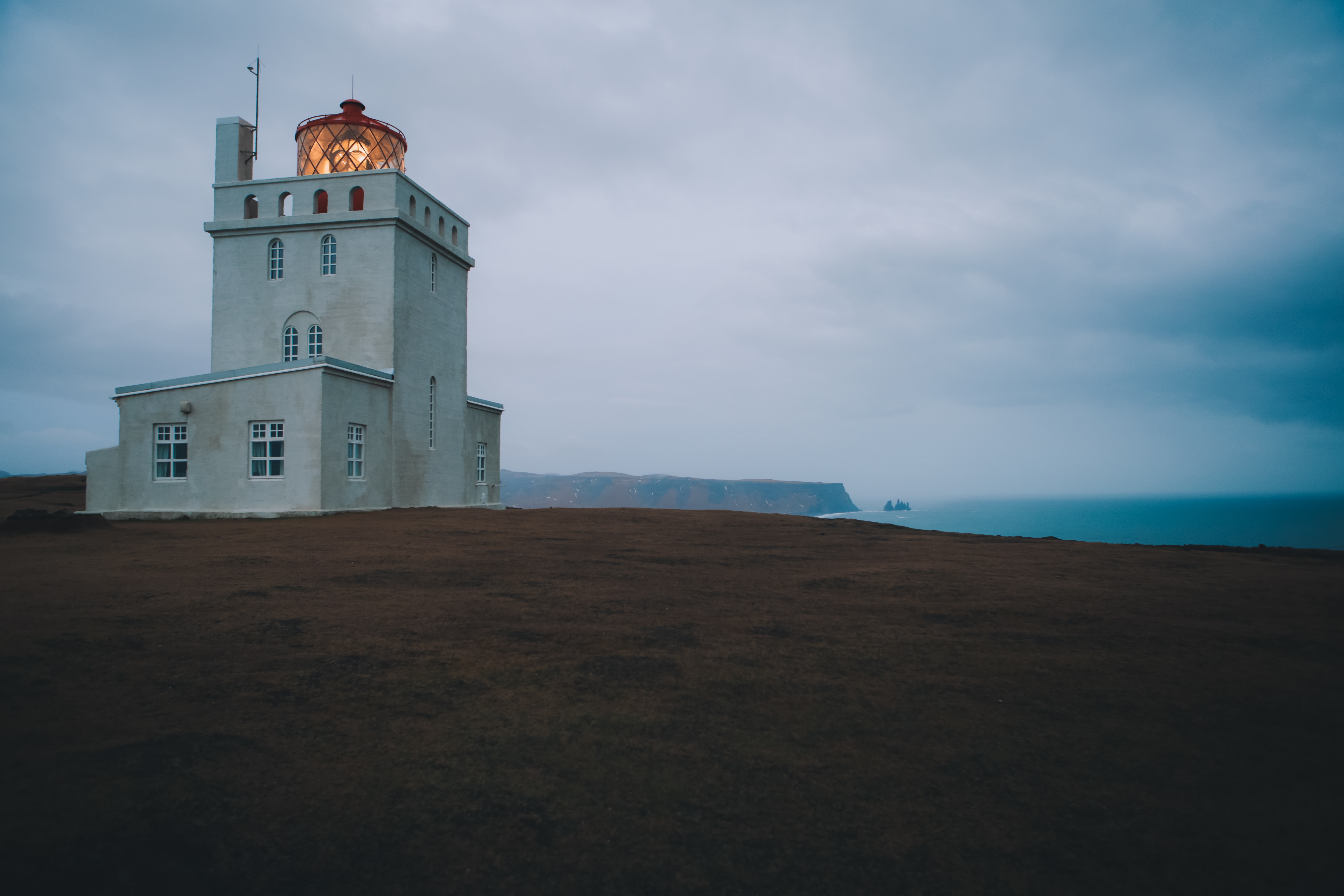 Dyrhólaey lighthouse with a coastal view under an overcast sky