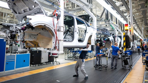 Mitarbeiter im VW-Werk Emden fertigen Autos. © dpa Foto: Sina Schuldt