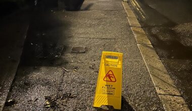 Wet floor sign on flooding road