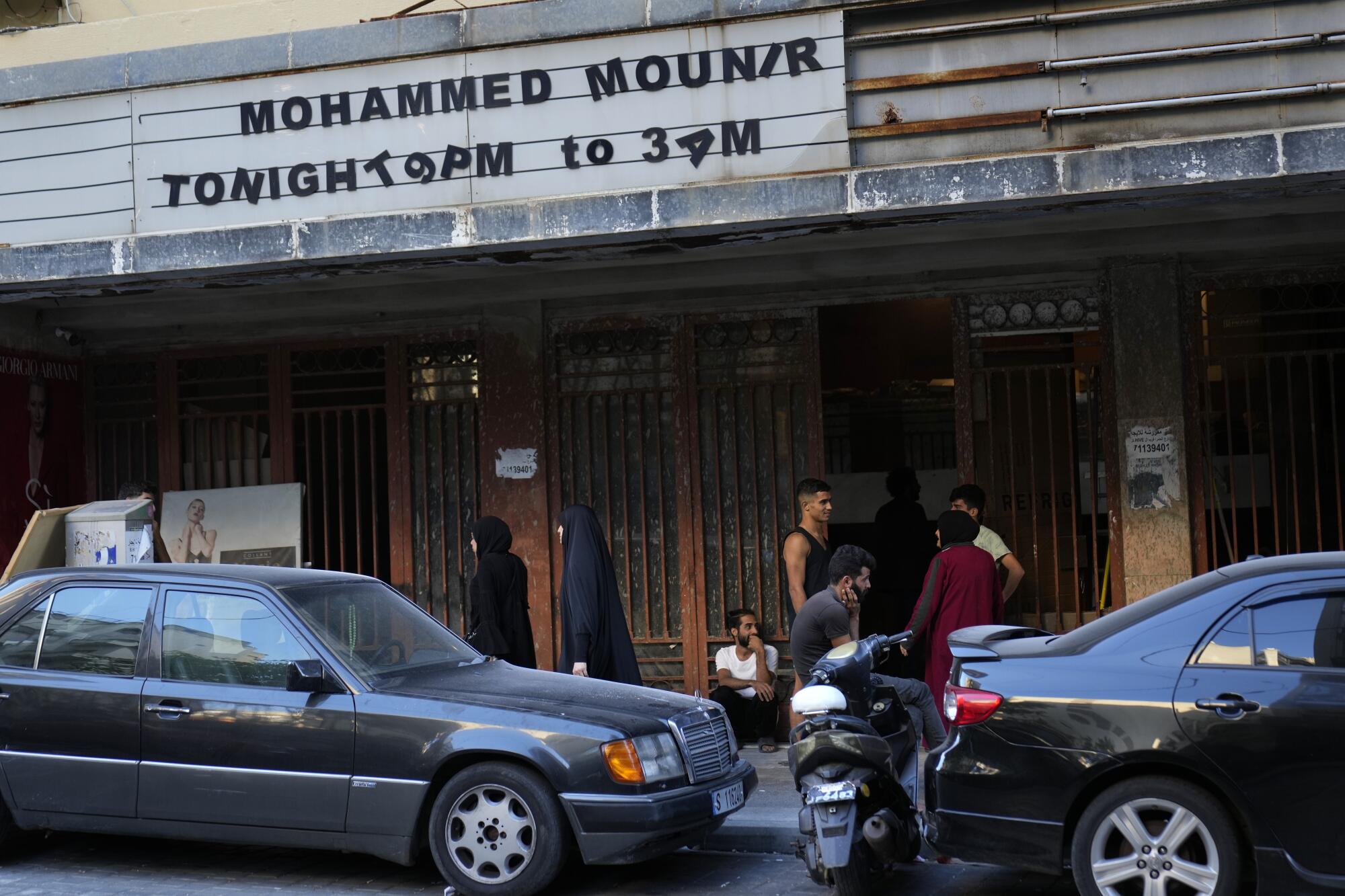 Displaced Lebanese gather outside a theater that has been turned into a shelter.