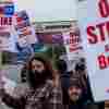 Boeing workers wave picket signs to passing drivers as they strike in Everett, Wash.. The machinists walked off the job more than six weeks ago as they bargain for higher pay and a return of their pension plan.