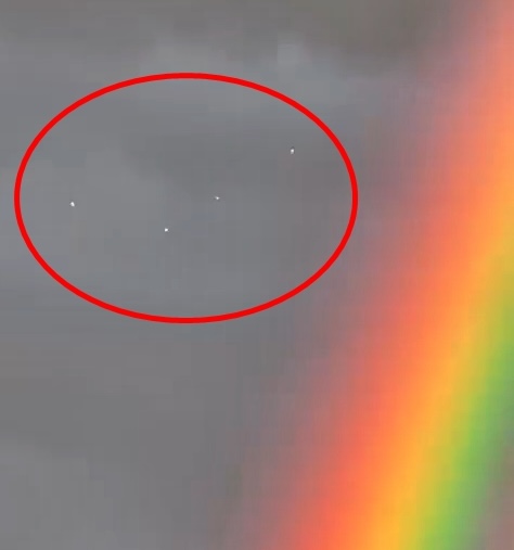 The cluster of four 'UFOs' were seen next to a rare double rainbow just days before the floods