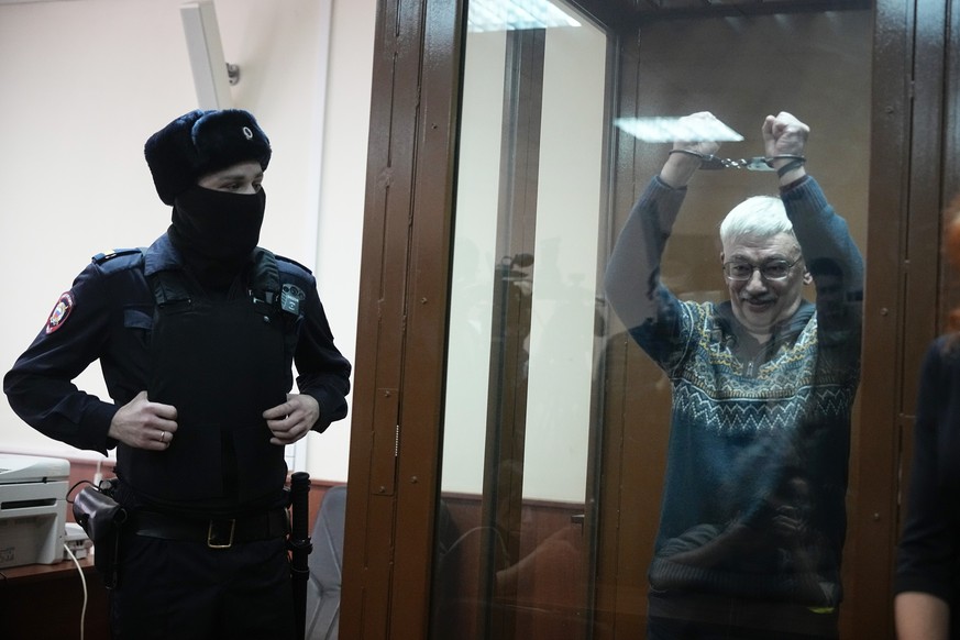 FILE ? Oleg Orlov, the co-chair of the Nobel Peace Prize-winning human rights group Memorial, gestures while in a glass defendants? cage in a court in Moscow, Russia, on Feb. 27, 2024, for a new trial ...