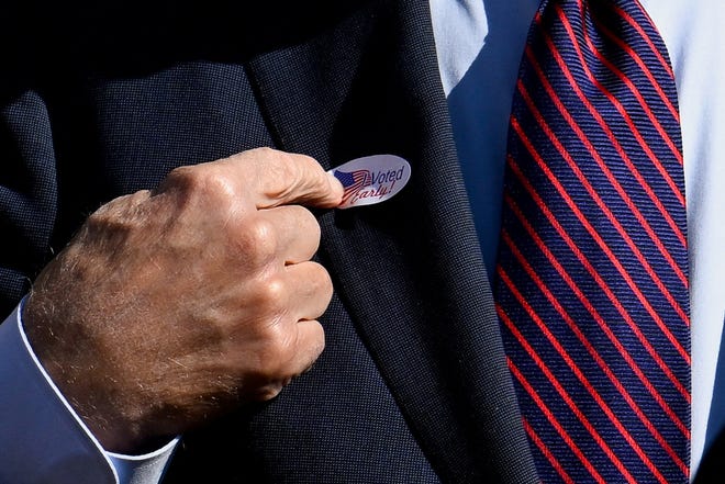 U.S. President Joe Biden points to an "I voted early" sticker on his lapel after voting in the 2024 presidential election, in New Castle, Delaware, U.S., October 28, 2024.