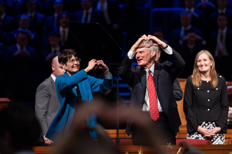 Elder David A. Bednar of the Quorum of the Twelve Apostles, right, and his wife, Sister Susan Bednar, make hearts with hands after speaking during a worldwide devotional for young adults held at Brigham Young University–Idaho on Sunday, Nov. 3, 2024.