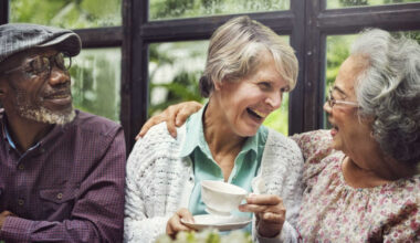 3 older people laughing together.