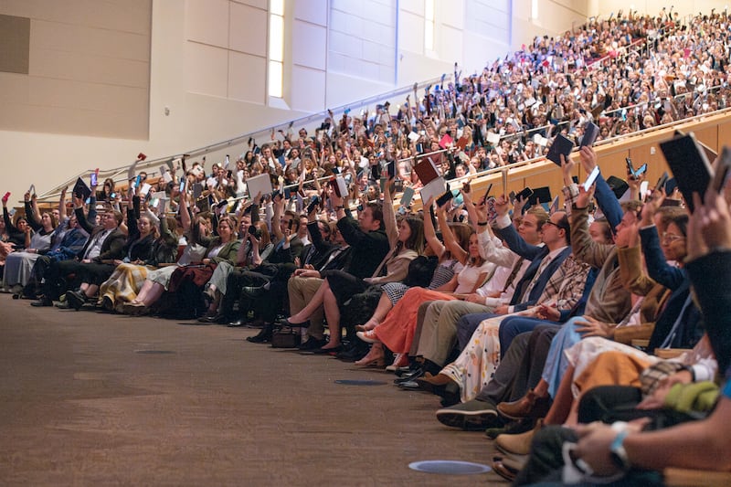 Students hold up their scriptures and note-taking devices to show they ready to learn during a worldwide devotional for young adults held at Brigham Young University–Idaho on Sunday, Nov. 3, 2024.  Elder David A. Bednar of the Quorum of the Twelve Apostles was the speaker.