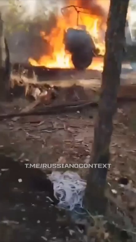 A Russian soldier records his burning vehicle as a consequence of a Ukrainian FPV drone strike