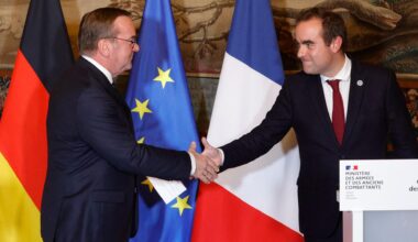 Boris Pistorius schüttelt Sebastien Lecornu während einer Pressekonferenz die Hand. Im Hintergrund sind die deutsche, die französische und die europäische Flagge zu sehen.