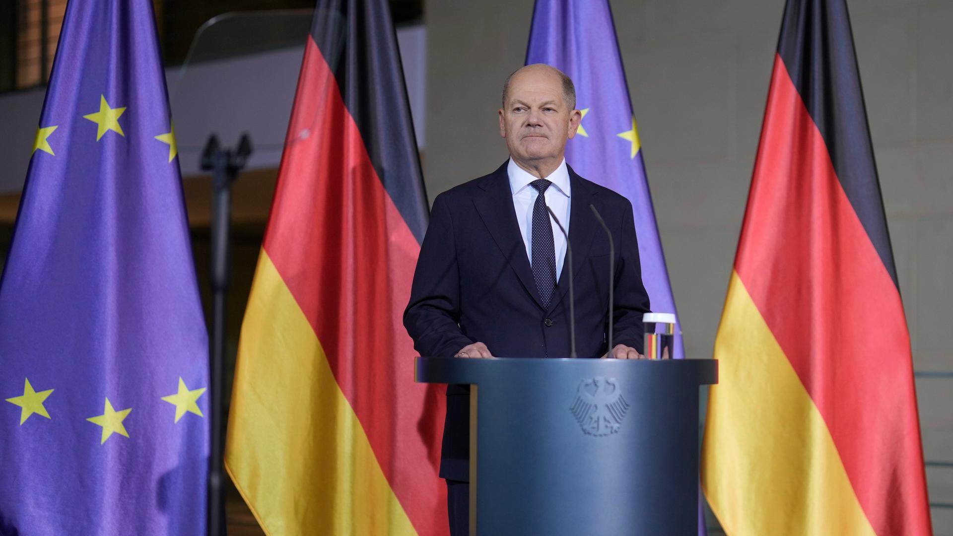 Bundeskanzler Scholz gibt ein Pressestatement vor dem Kanzleramt - er steht vor deutschen und europäischen Flaggen. 